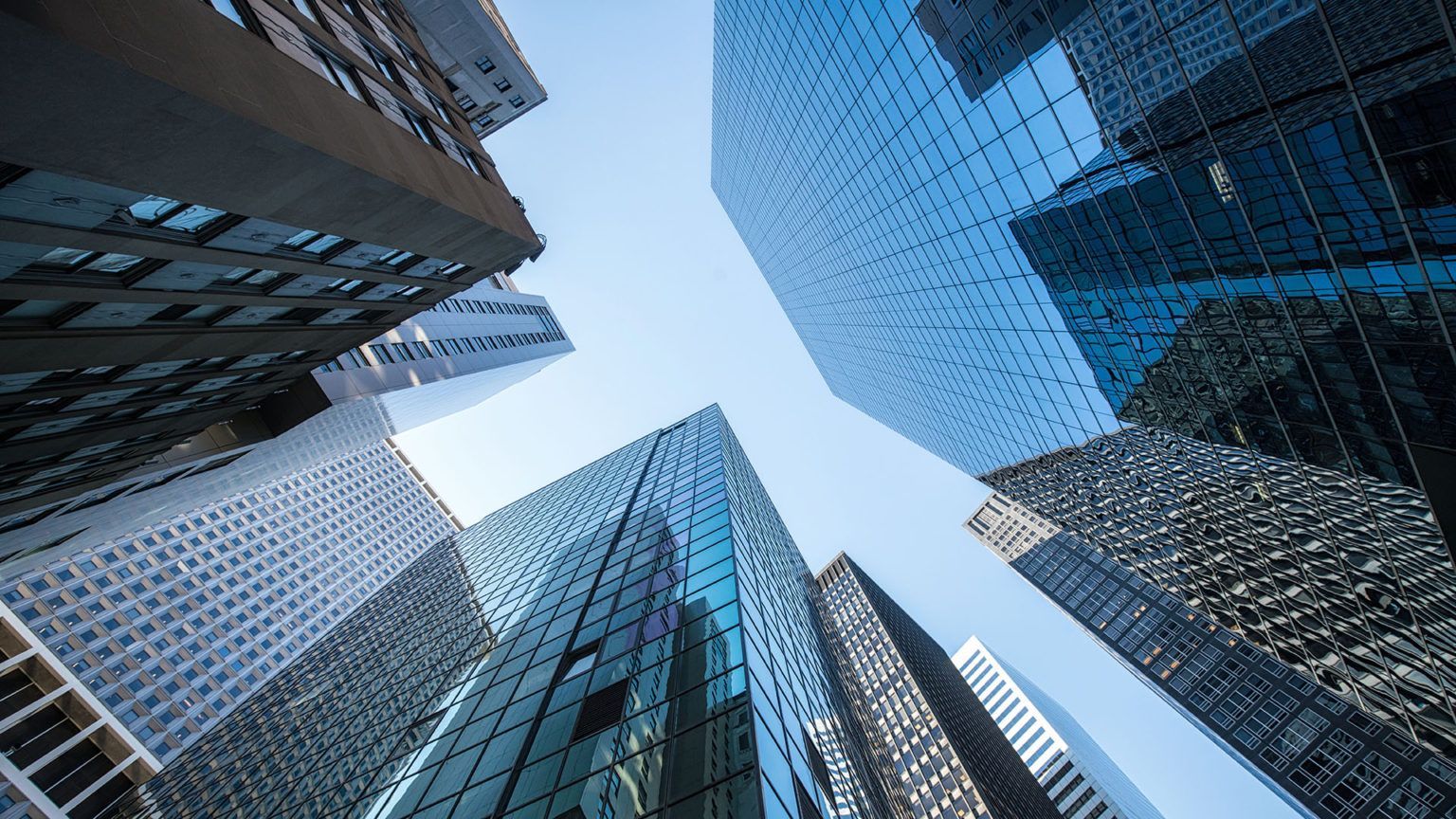 Prédios corporativos representando investimentos empresariais em tecnologia da informação e infraest