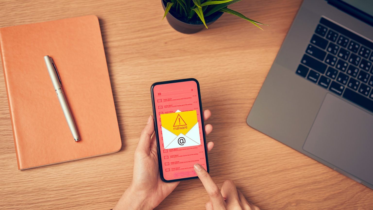 Pessoa segurando smartphone com alerta de vírus, representando ataques de malwares stealers e roubo 