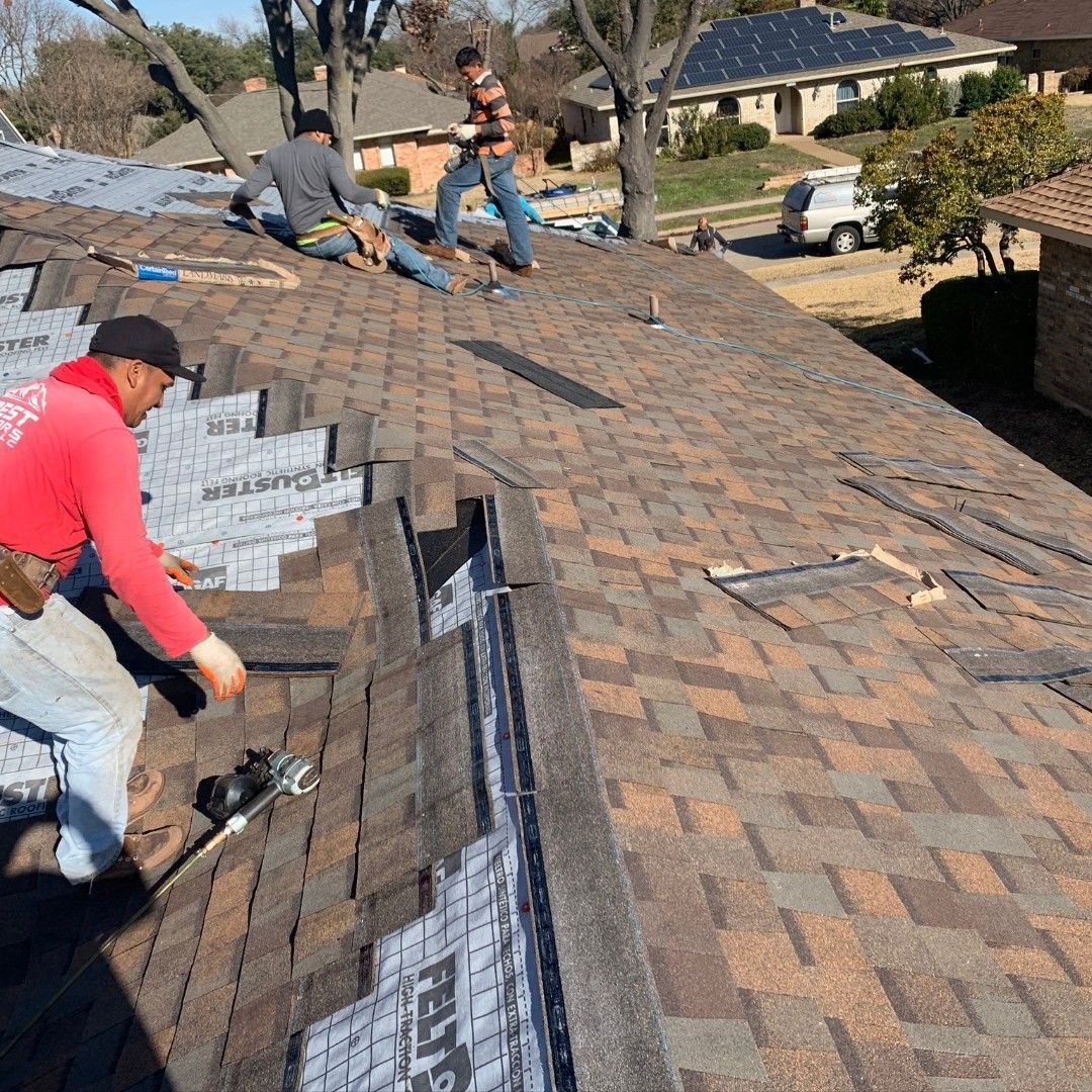 A group of men are working on the roof of a house.