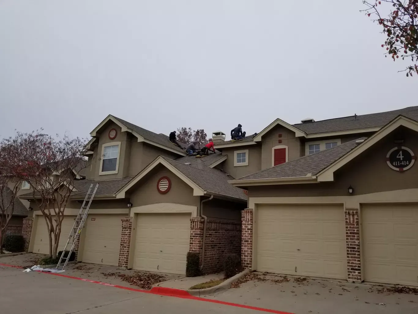 A group of people are working on the roof of a house