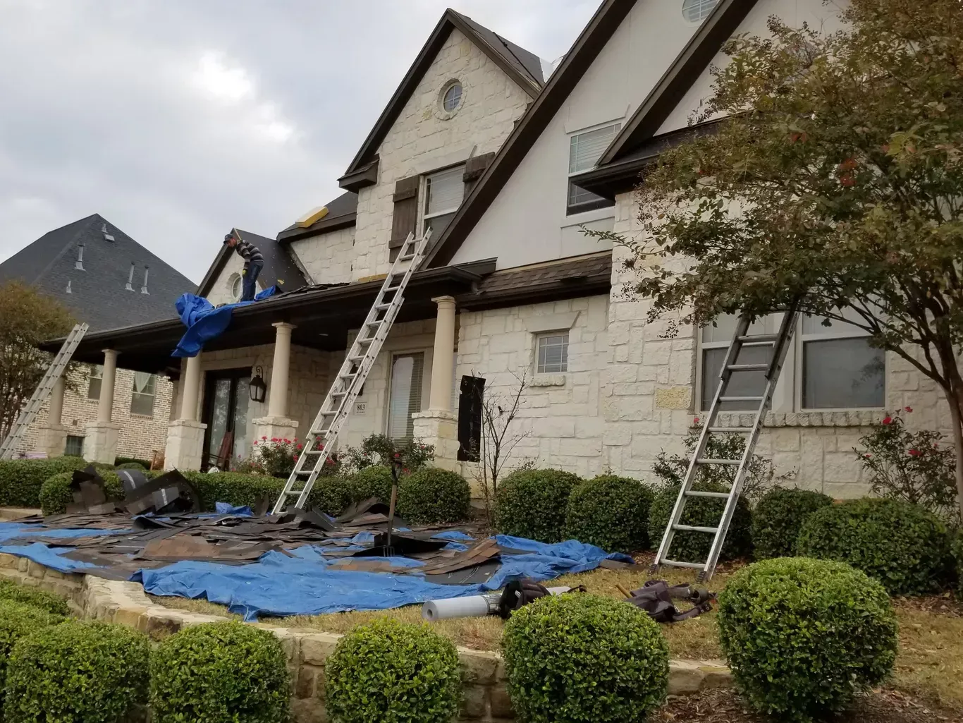 A large white house with a ladder on the front porch.