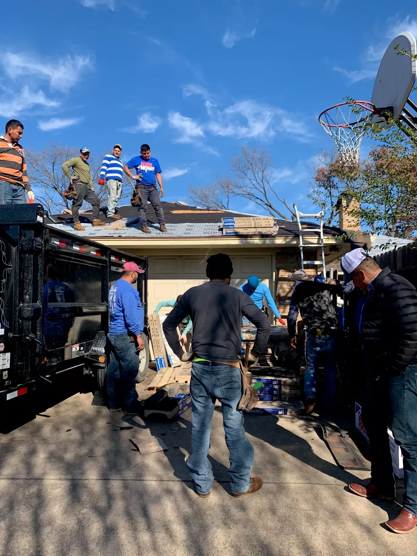 A group of men are working on the roof of a house.