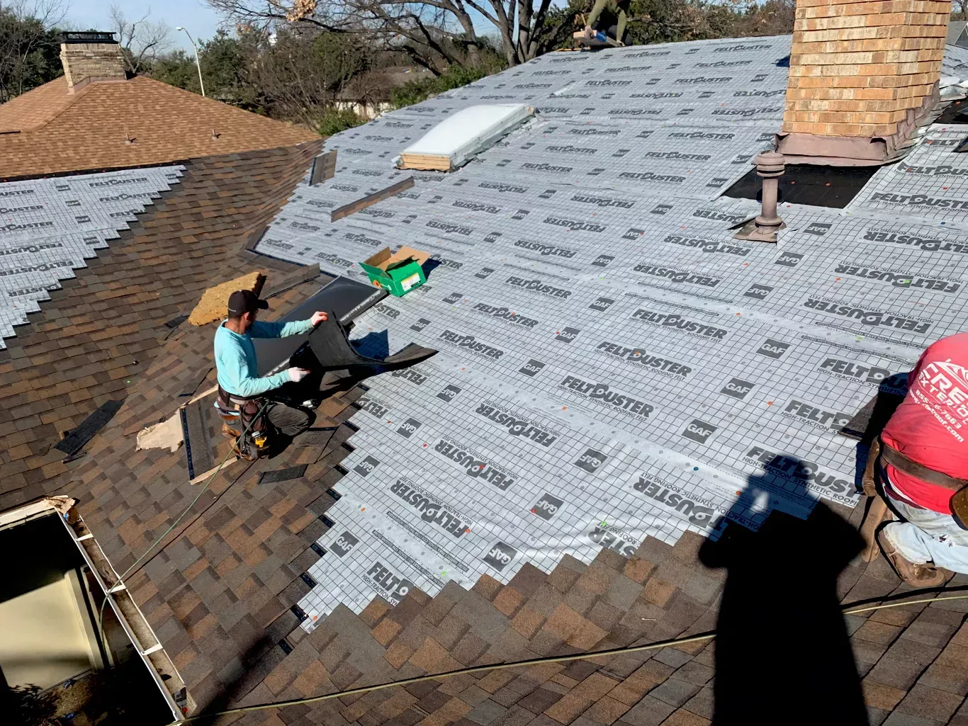 A man is working on the roof of a house.