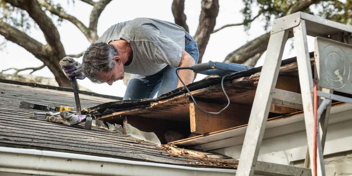 A man is working on the roof of a house.
