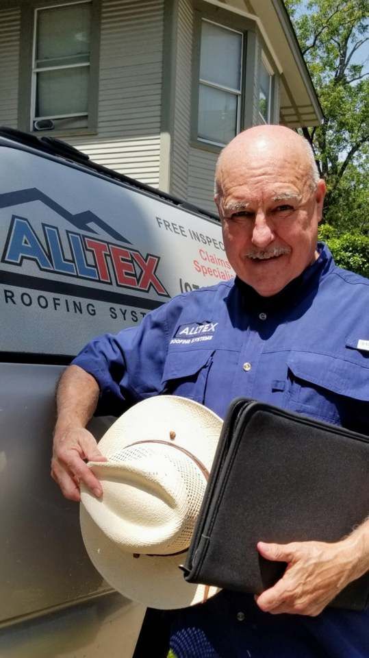 A man in a blue shirt is holding a cowboy hat and a clipboard.
