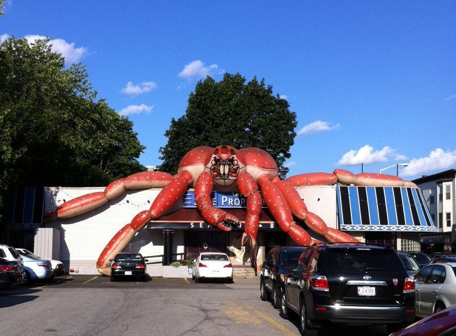 A giant red spider is on the side of a building