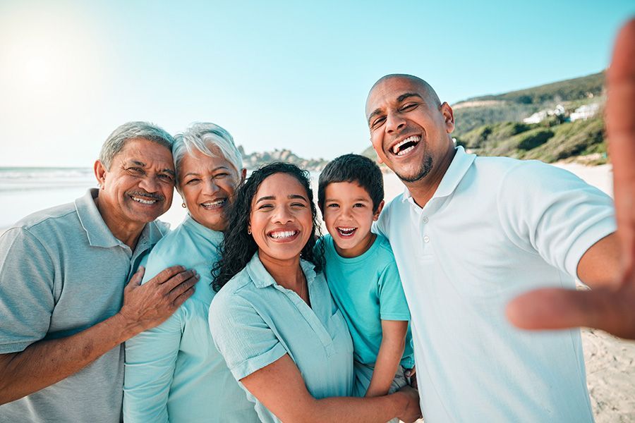 A family is taking a selfie on the beach.