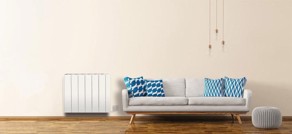 White sofa with blue cushions, with hanging lights above.