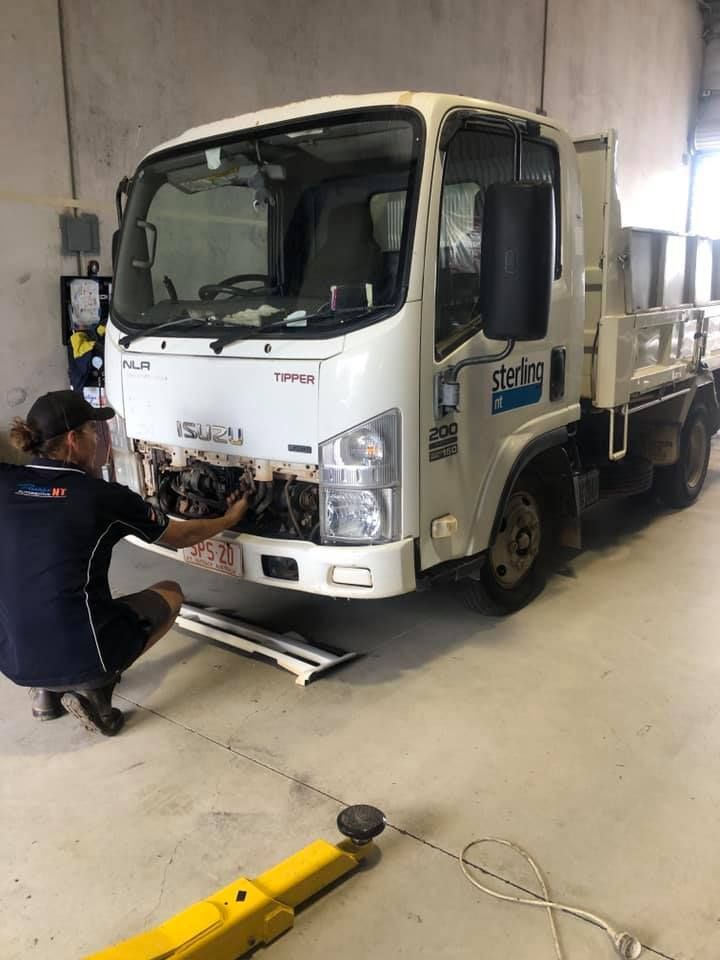 A Man Is Working On The Front Of A Truck In A Garage — Prestige Automotive NT In Yarrawonga, NT