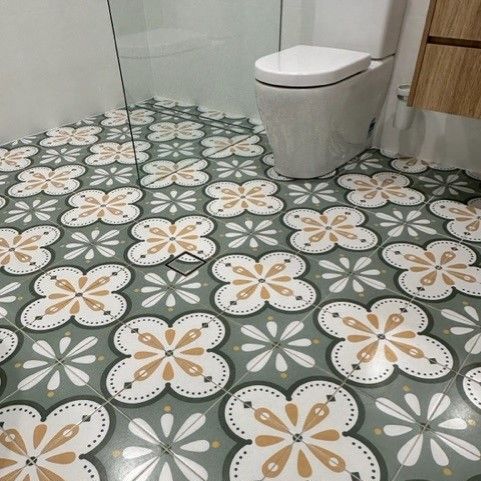 A Bathroom With A Toilet And A Tiled Floor With Flowers On It  — Stone Arc in Kincumber, NSW