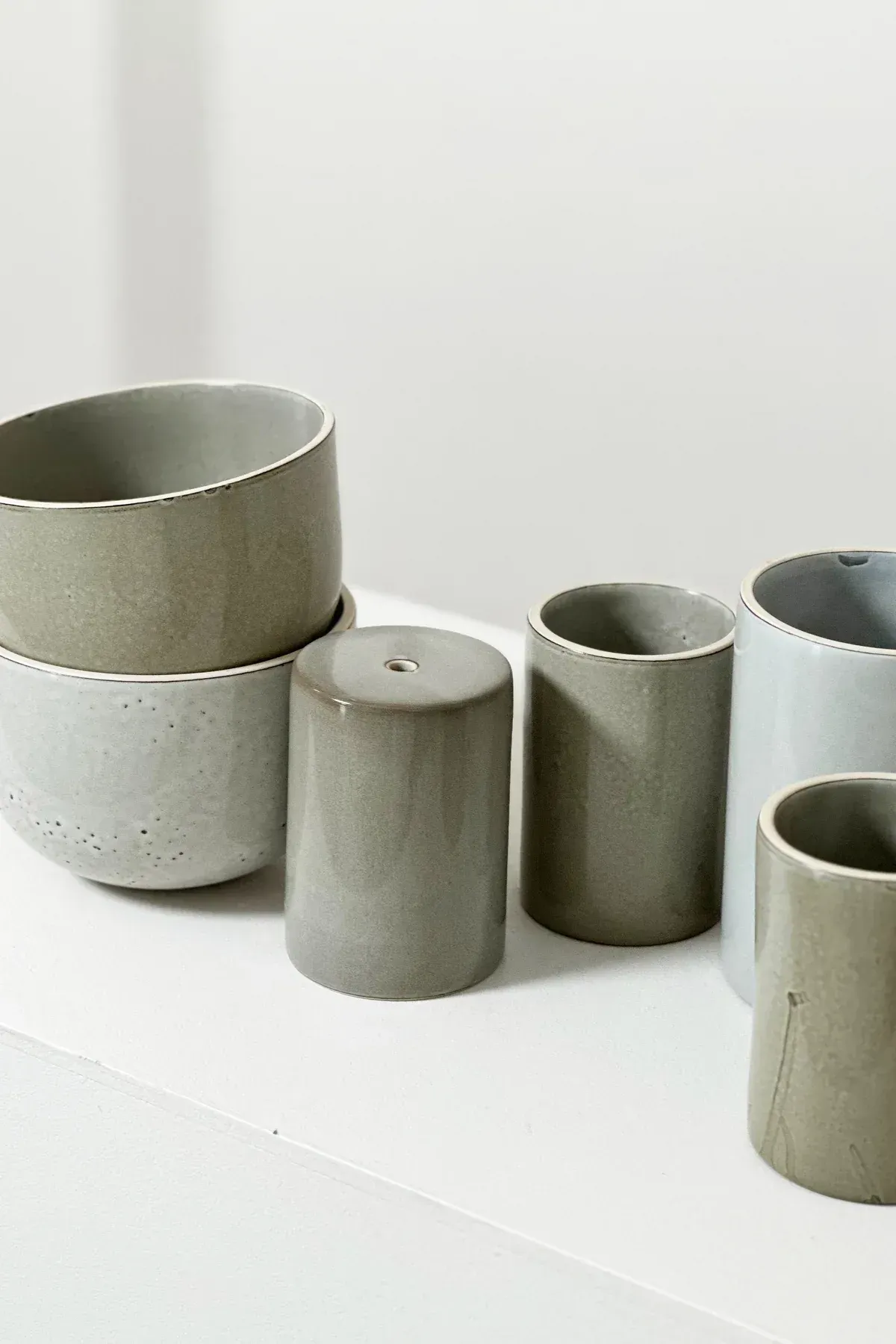 Gray ceramic cups and containers stacked on a white surface — Stone Arc in Kincumber, NSW