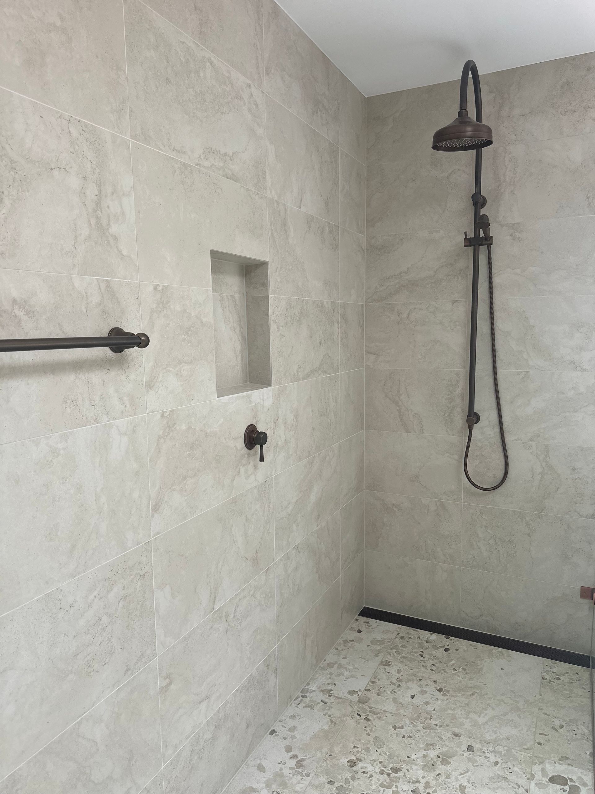 Shower With Light Gray Stone Walls, Black Fixtures, and a Small Niche — Stone Arc in Kincumber, NSW