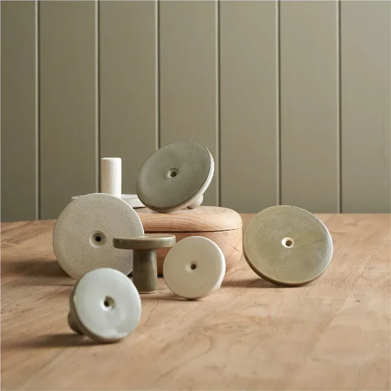 Collection of round, ceramic cabinet knobs in various muted colours on a wooden surface — Stone Arc in Kincumber, NSW