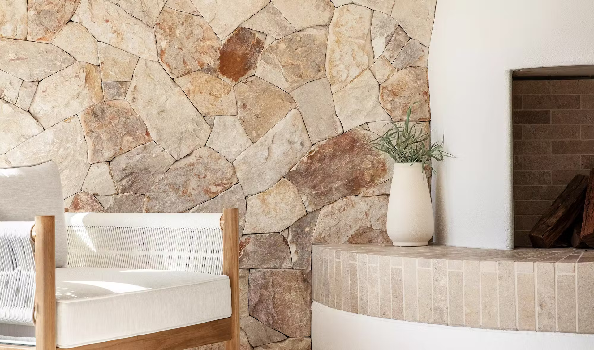 Stone Wall Interior With White Fireplace, Vase of Greenery, and Wood-framed Chair — Stone Arc in Kincumber, NSW