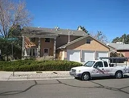 A white truck is parked in front of a house.