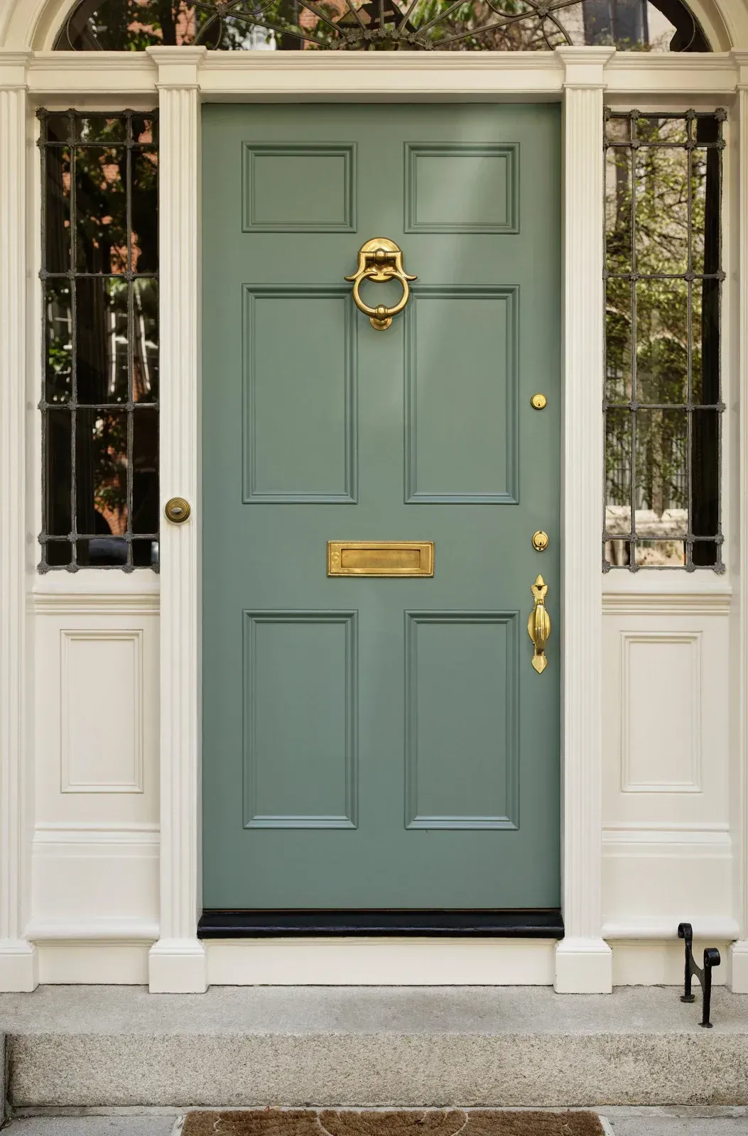 A green front door with a brass door knocker