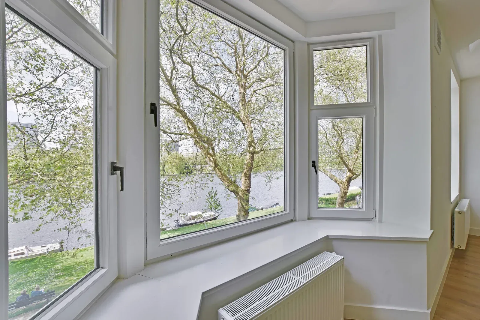 A large window with a view of a river and trees.