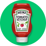 A bottle of heinz tomato ketchup on a green background.