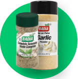 Two jars of garlic powder are sitting next to each other on a green background.