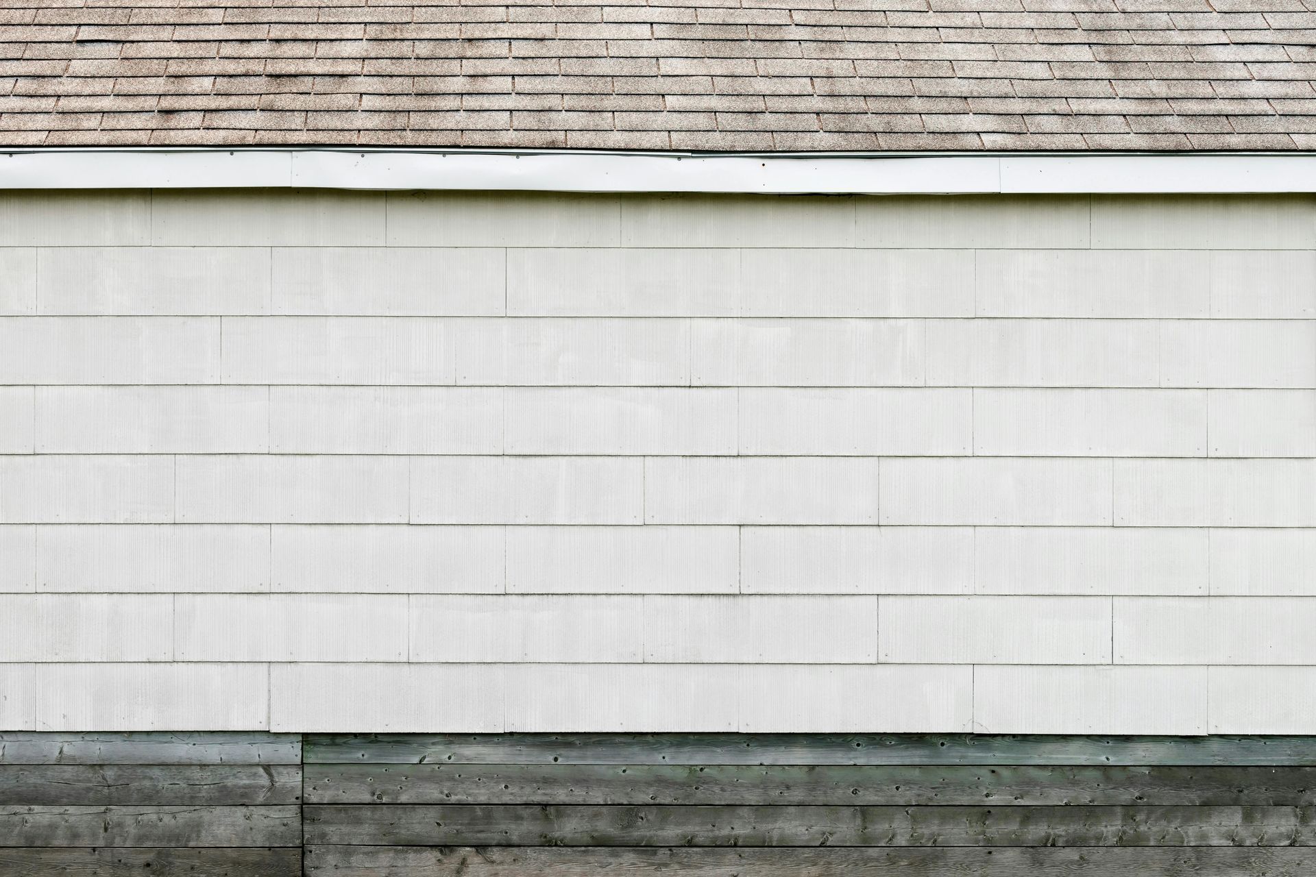 A white garage door with a brick roof and a concrete foundation.