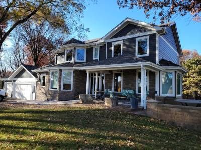 A large house with a large porch and a white truck parked in front of it.