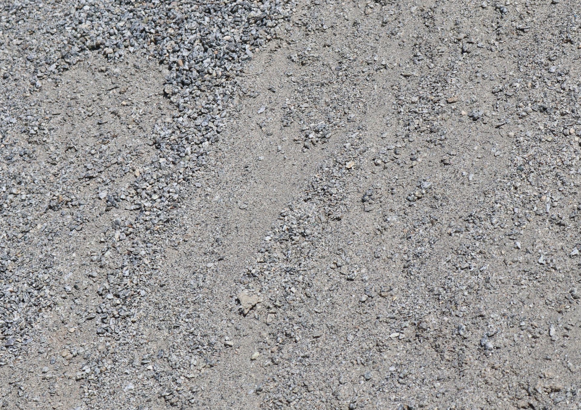 A close up of a gray concrete surface with a lot of small stones.