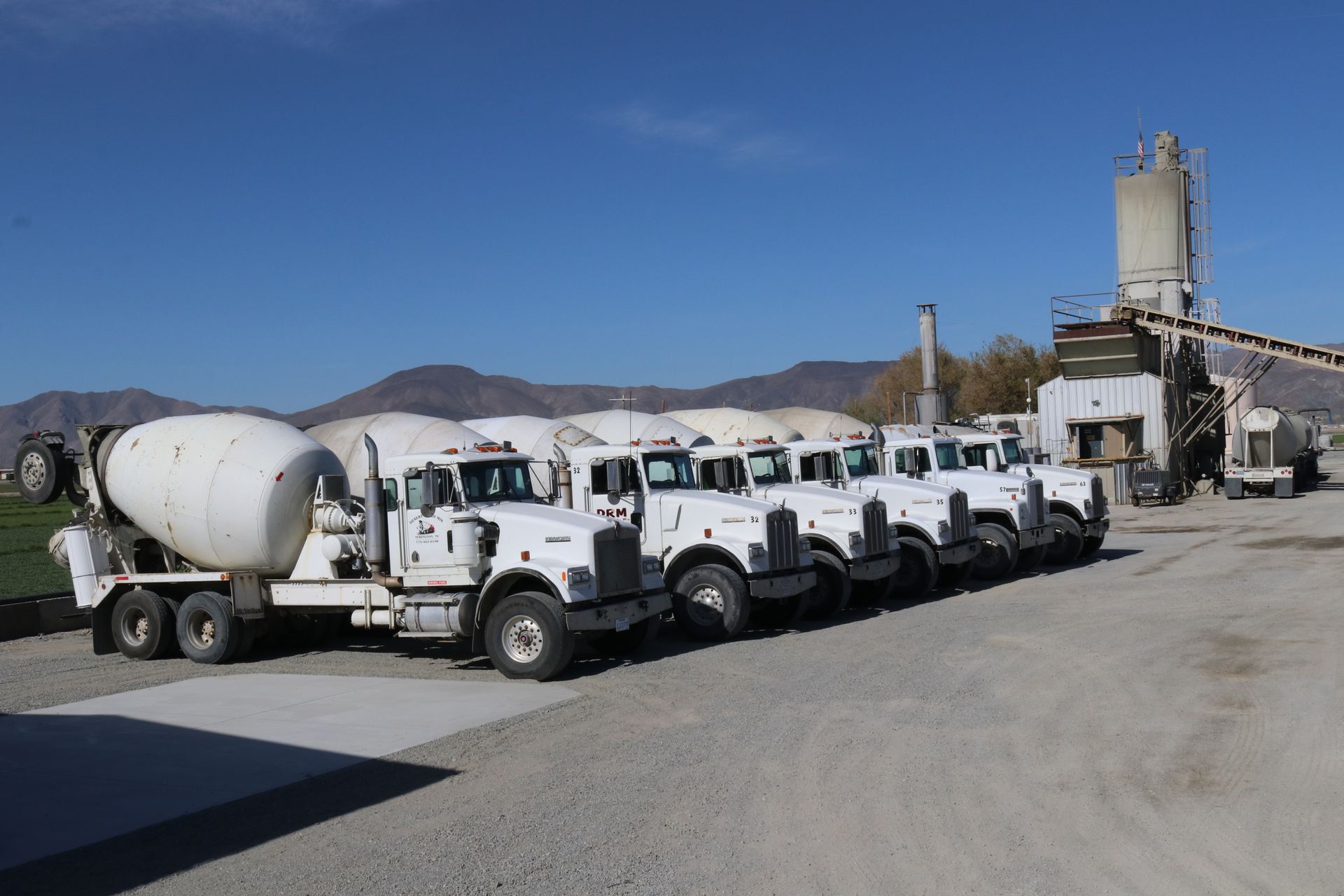 A row of cement trucks are parked in a parking lot at Yerington, NV