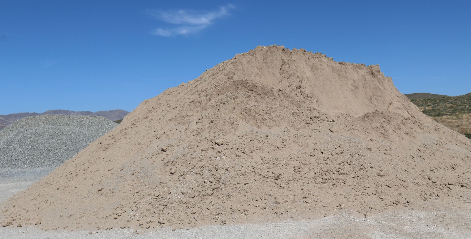 A large pile of dirt is sitting on top of a dirt hill.