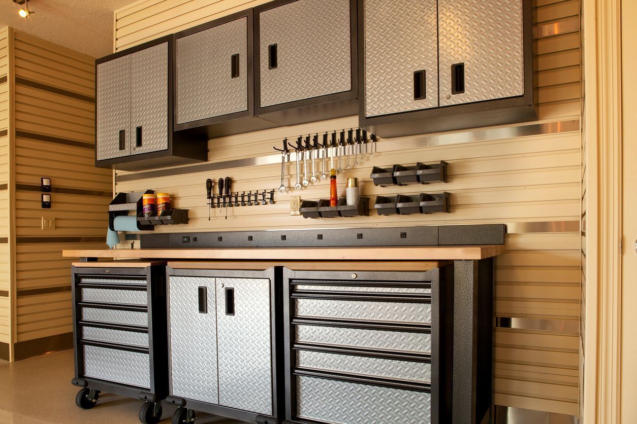 Garage workshop with storage cabinets, workbench, and tools.