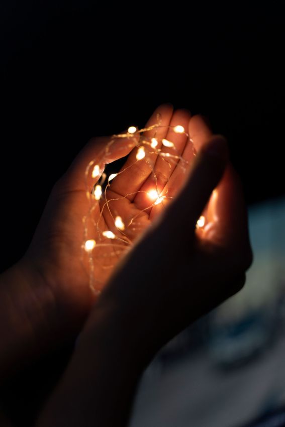 A person is holding a string of lights in their hands.