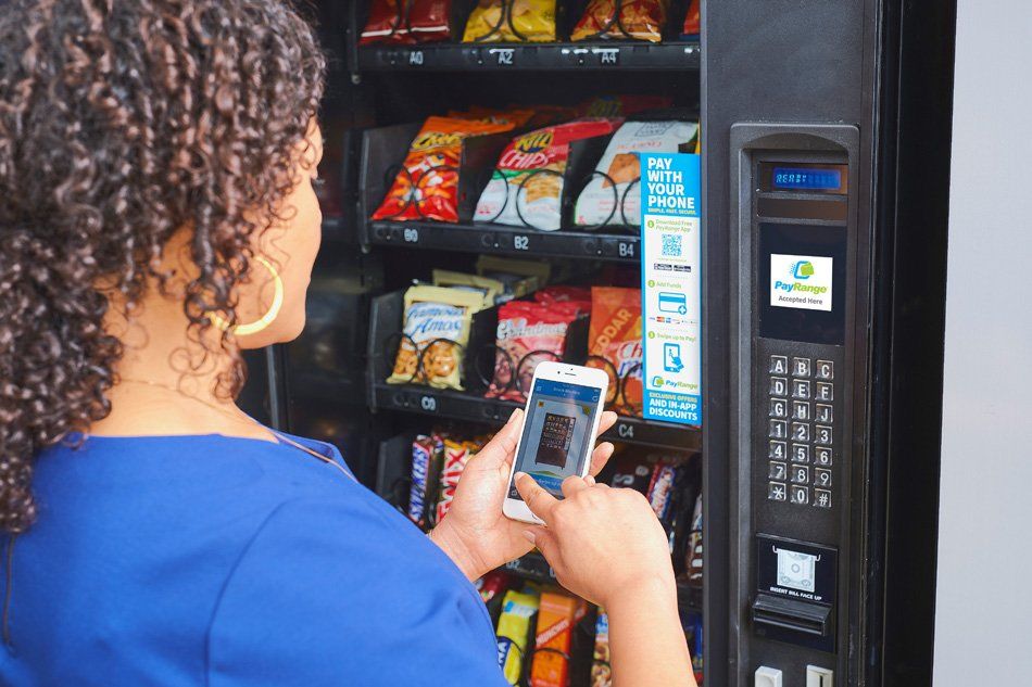 Woman Using Her Phone to Pay — Chicago, IL — Avcoa Vending
