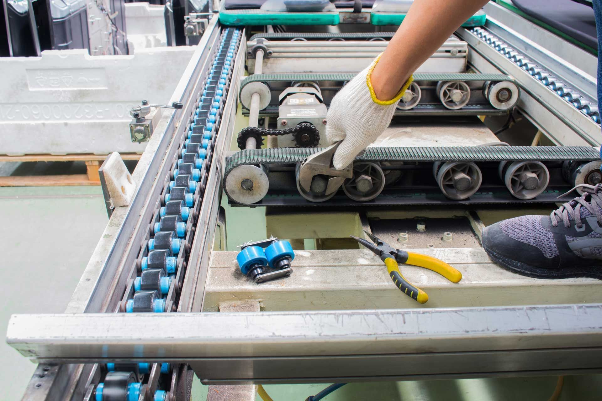A person is working on a conveyor belt in a factory.