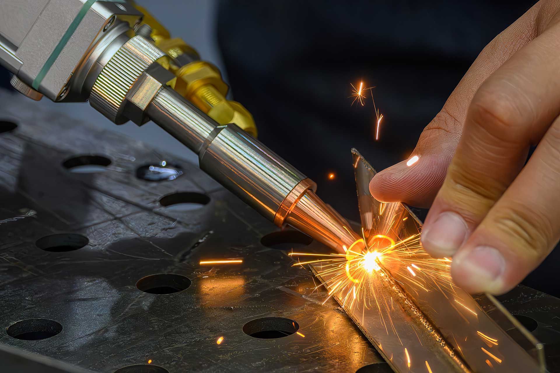 A person is welding a piece of metal with a machine.