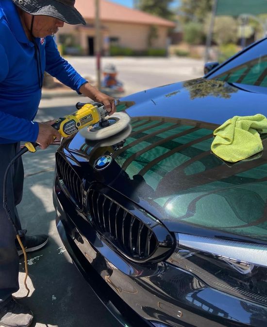 Two cars are being washed in a parking lot.