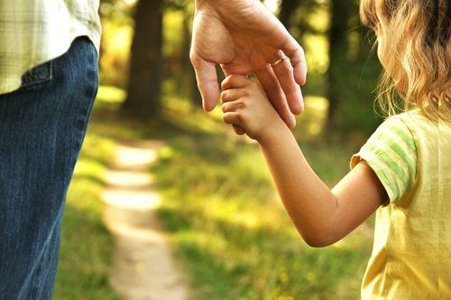 una bambina che passeggia con un adulto