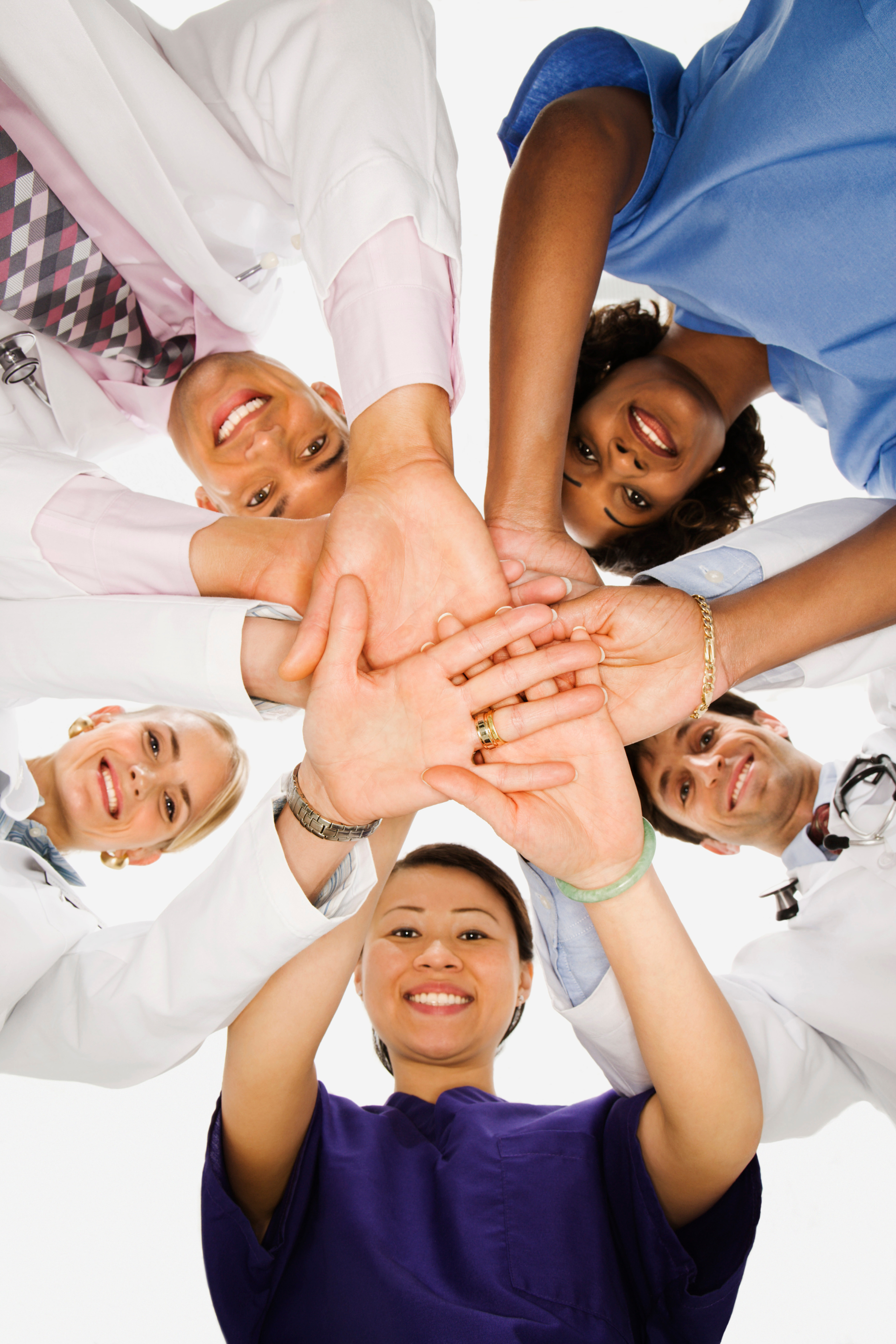 A group of people are putting their hands together in a circle