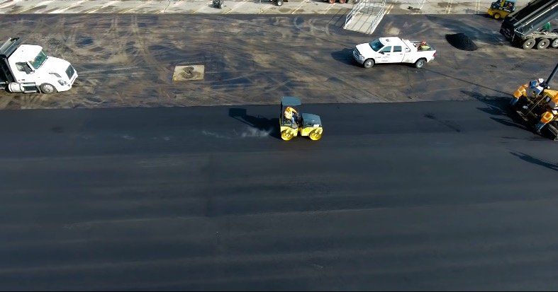 Greater Milwaukee Asphalt Paving uses a roller to compact the new asphalt for a parking lot in St. Francis, WI