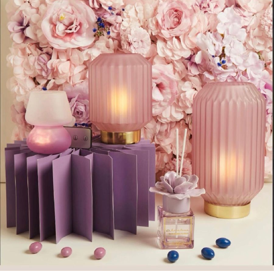 Ciondolo religioso rotondo in ceramica con testo, campanellino e sacchetto in tessuto beige.