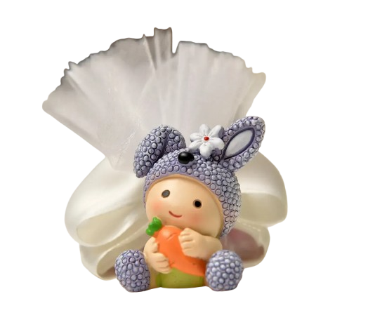 Statuetta vestita da coniglio che tiene in mano una carota, seduta davanti a un sacchetto di organza bianco.