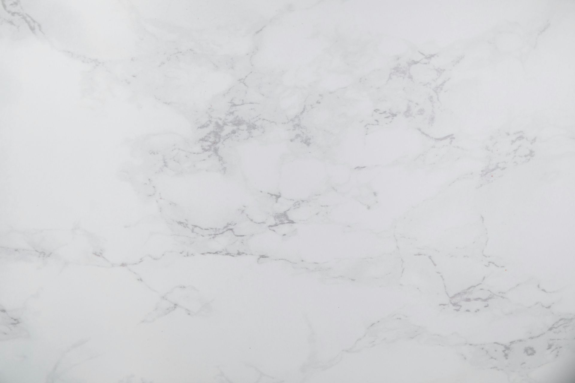 White marble surface with subtle, light grey veining in a soft, elegant pattern.