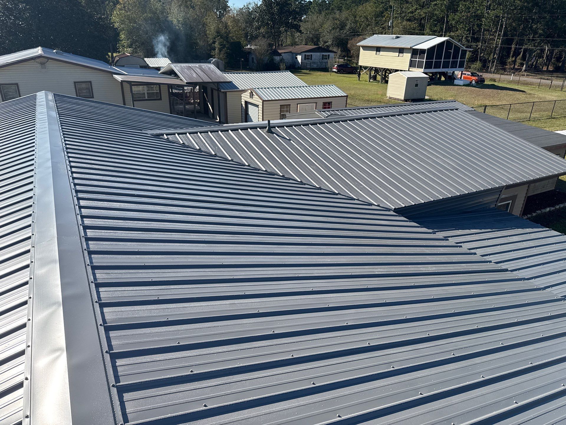 Gray metal roof on a residential building, angled view on a sunny day.