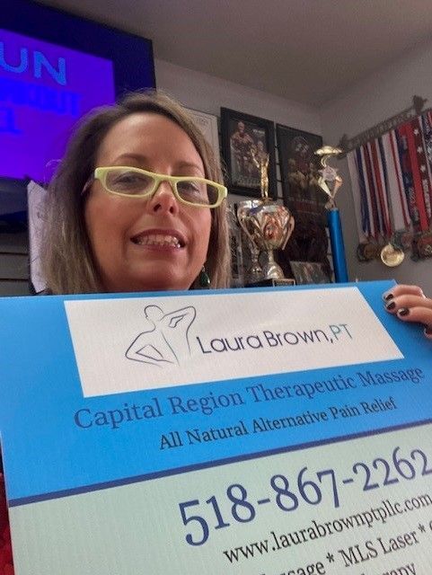 Owner raising a poster - Clifton Park, NY - Capital Region Calmare & Massage PLLC