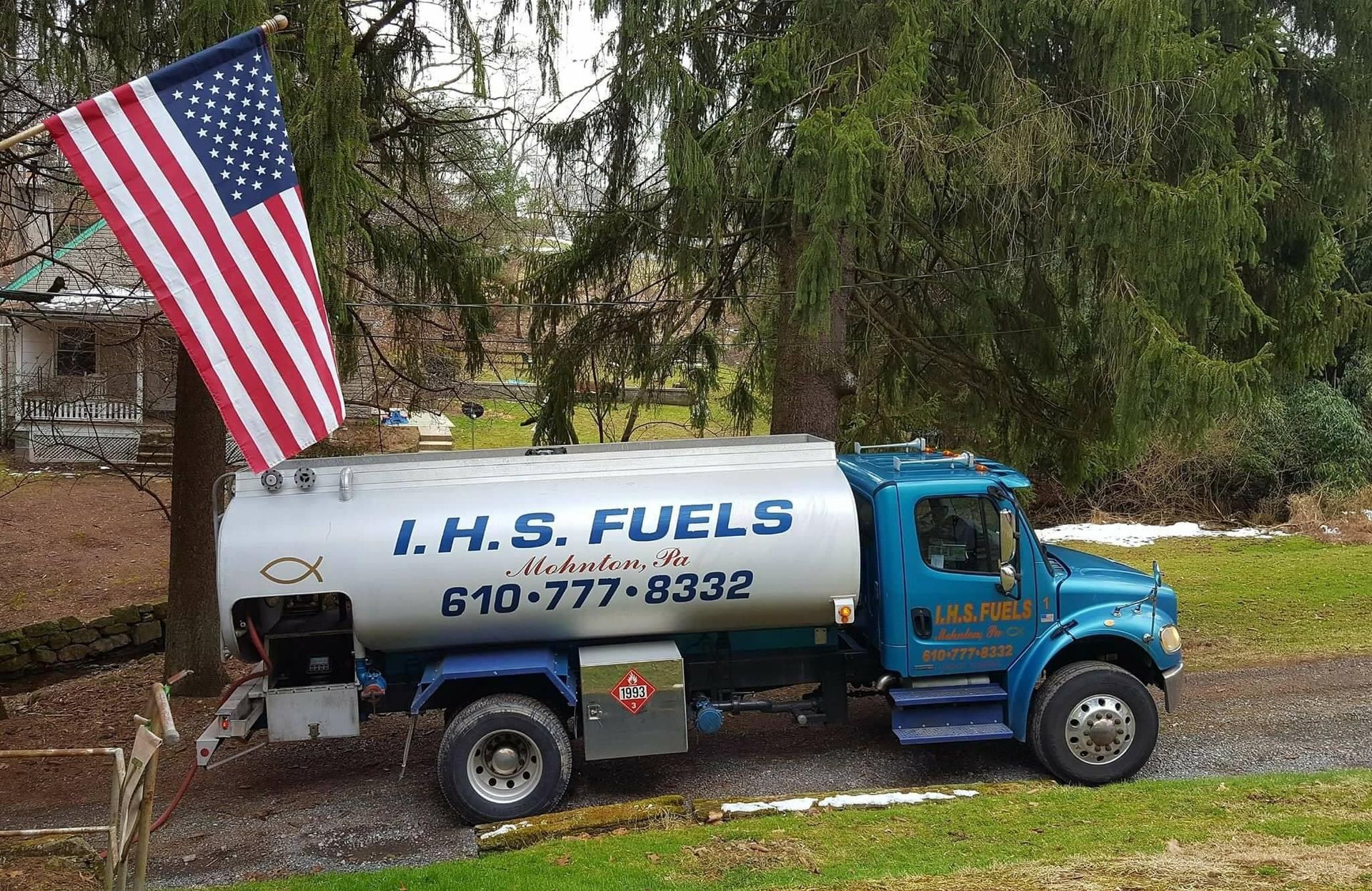A fuel truck is parked next to an american flag