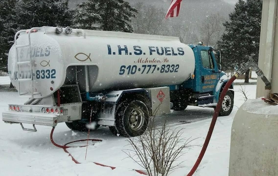 A yellow and red tanker truck is parked in a parking lot.