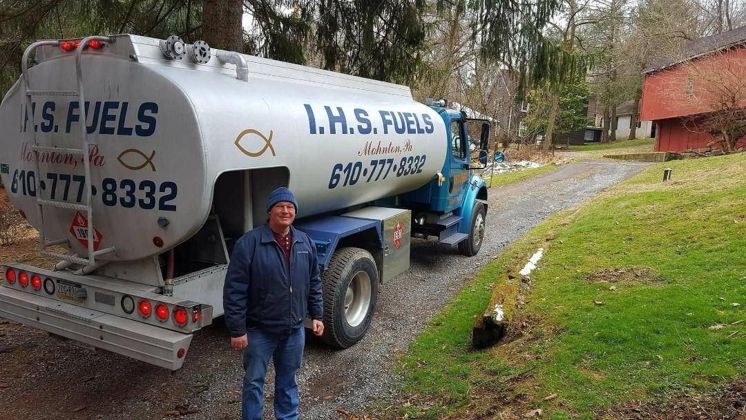 Two tanker trucks are parked next to each other on the side of the road.