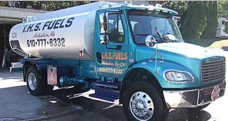 A blue fuel truck is parked in front of a house