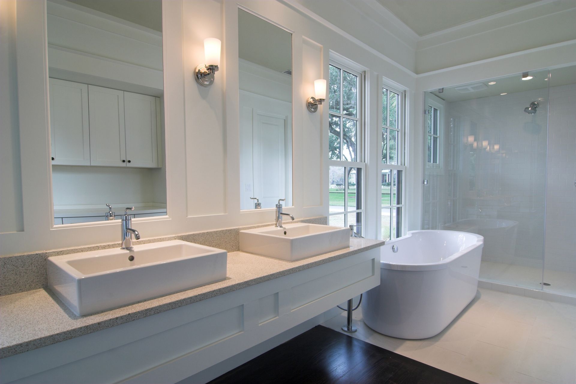 Bright modern bathroom with double sinks, large mirror, soaking tub, and glass shower. Bright modern bathroom with double sinks, large mirror, soaking tub, and glass shower.