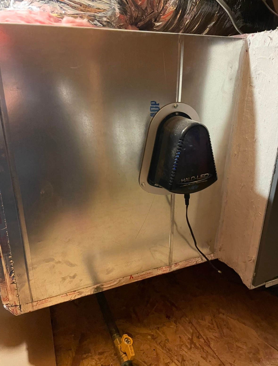 Black HVAC sensor installed on a metal duct. The sensor has a wire attached.