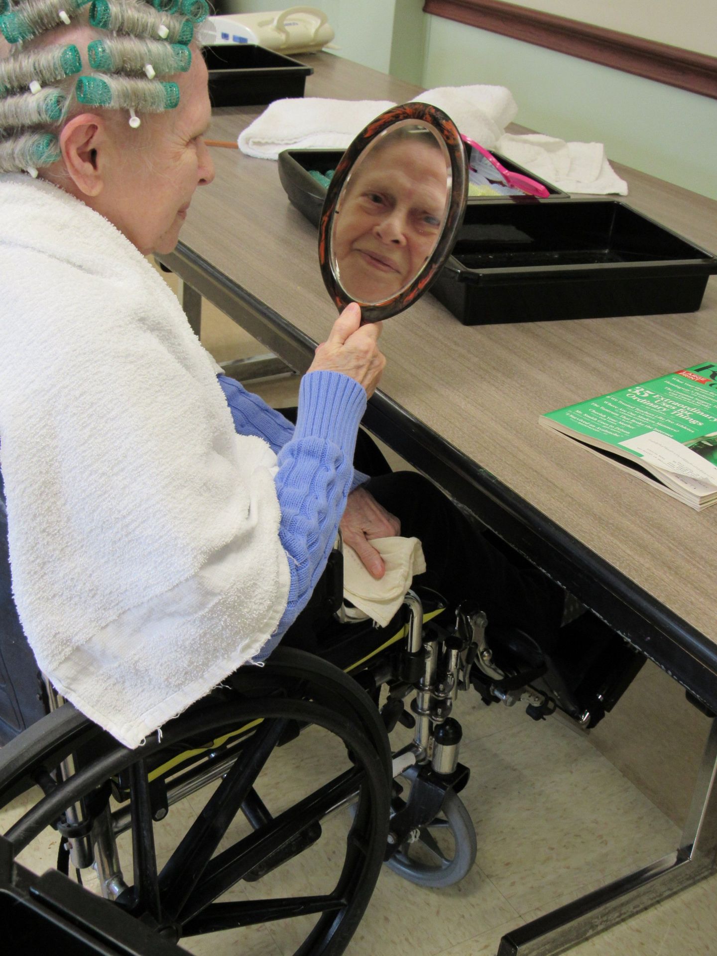 Elder getting her hair done and looking in mirror at Lenawee Medical Care Facility in Adrian, MI