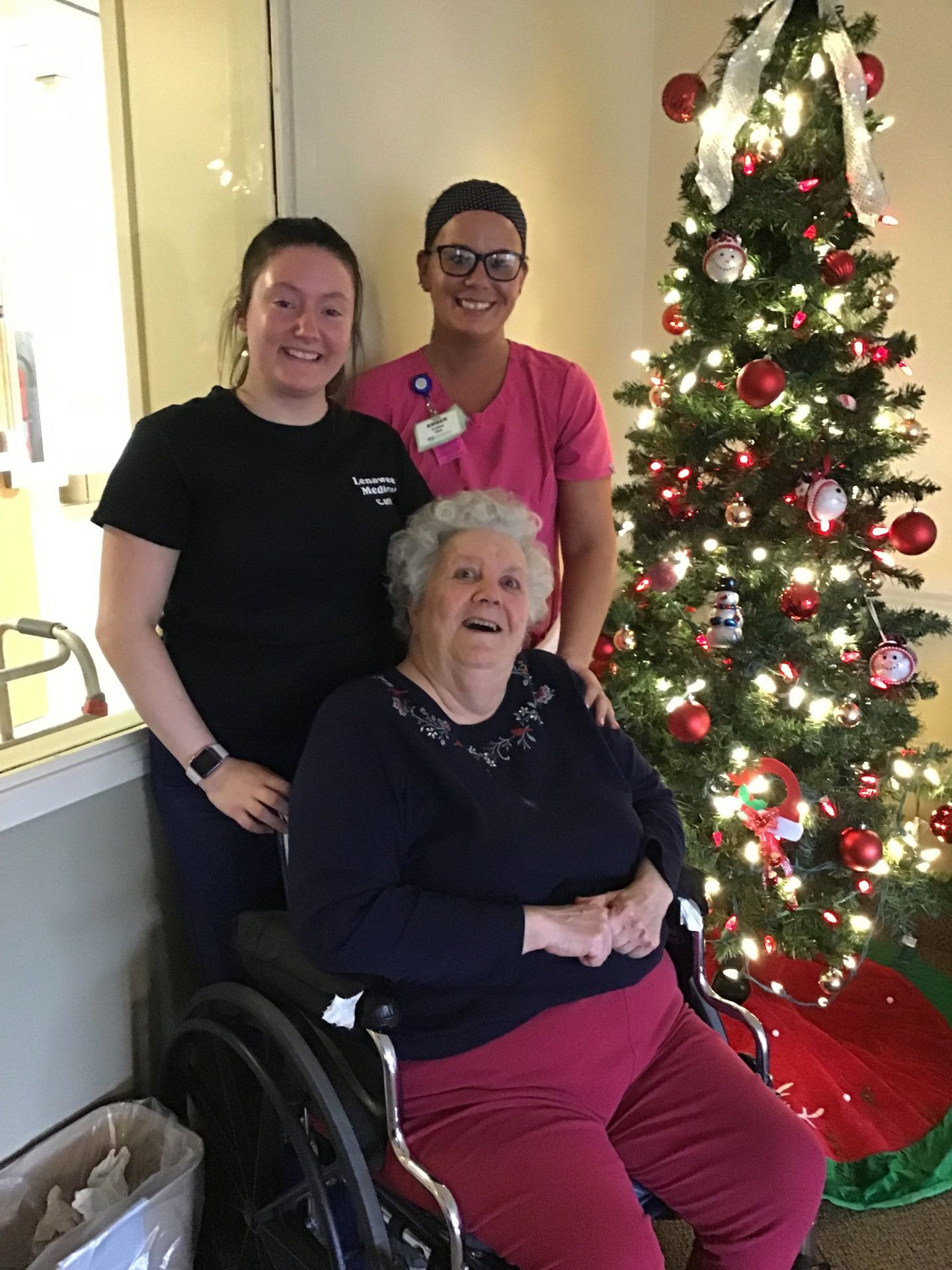 Elder posing with staff by Christmas tree at Lenawee Medical Care Facility in Adrian, MI